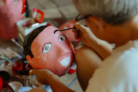 Artista che dipinge una maschera di scena fatta a mano